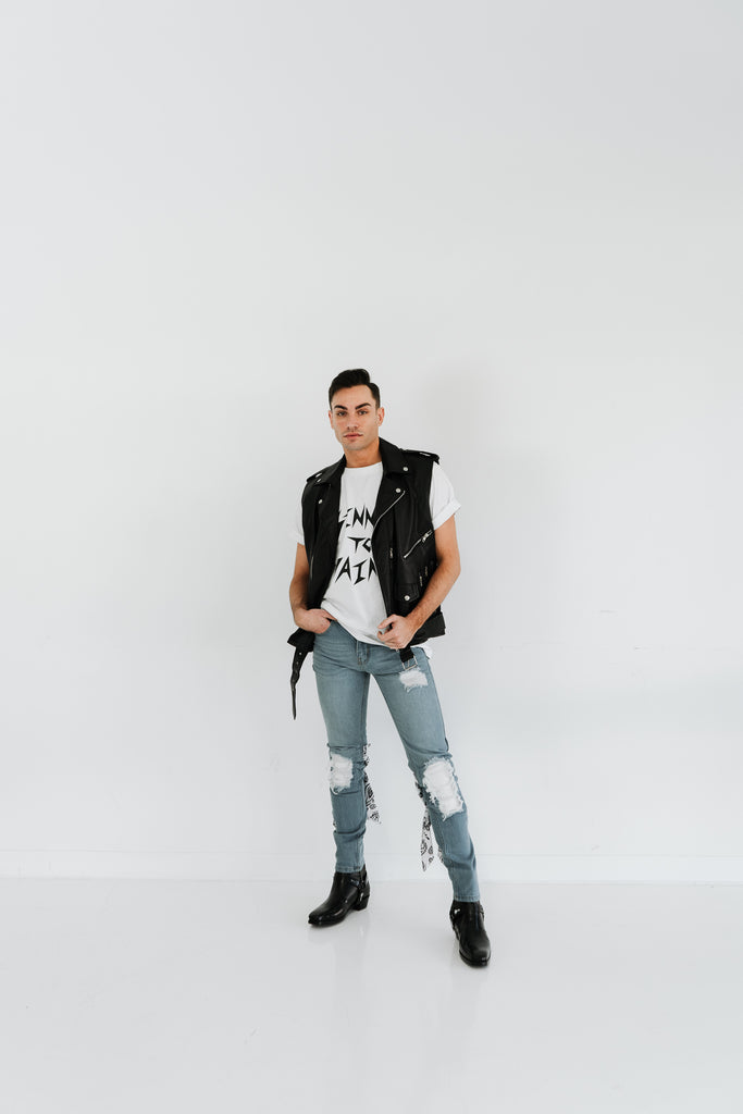 BIKER BLACK LEATHER VEST WITH SINNER TO SAINT WHITE TEE AND LEATHER PATCH BIKER DENIM JEANS